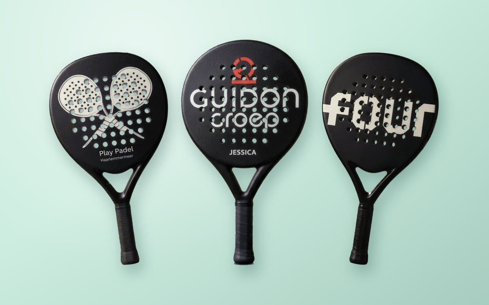 Drie custom padel rackets met de logo’s van Play Padel, Guidon Groep en FOUR, op een mintgroene achtergrond